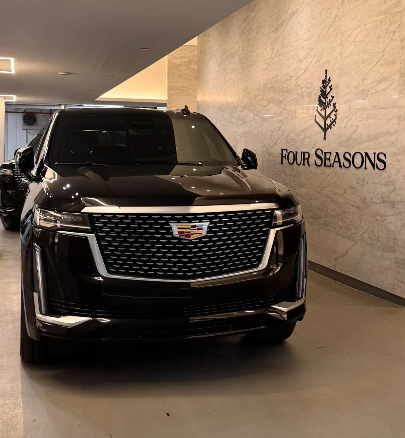 Cadillac Escalade negro junto al letrero del hotel Four Seasons.