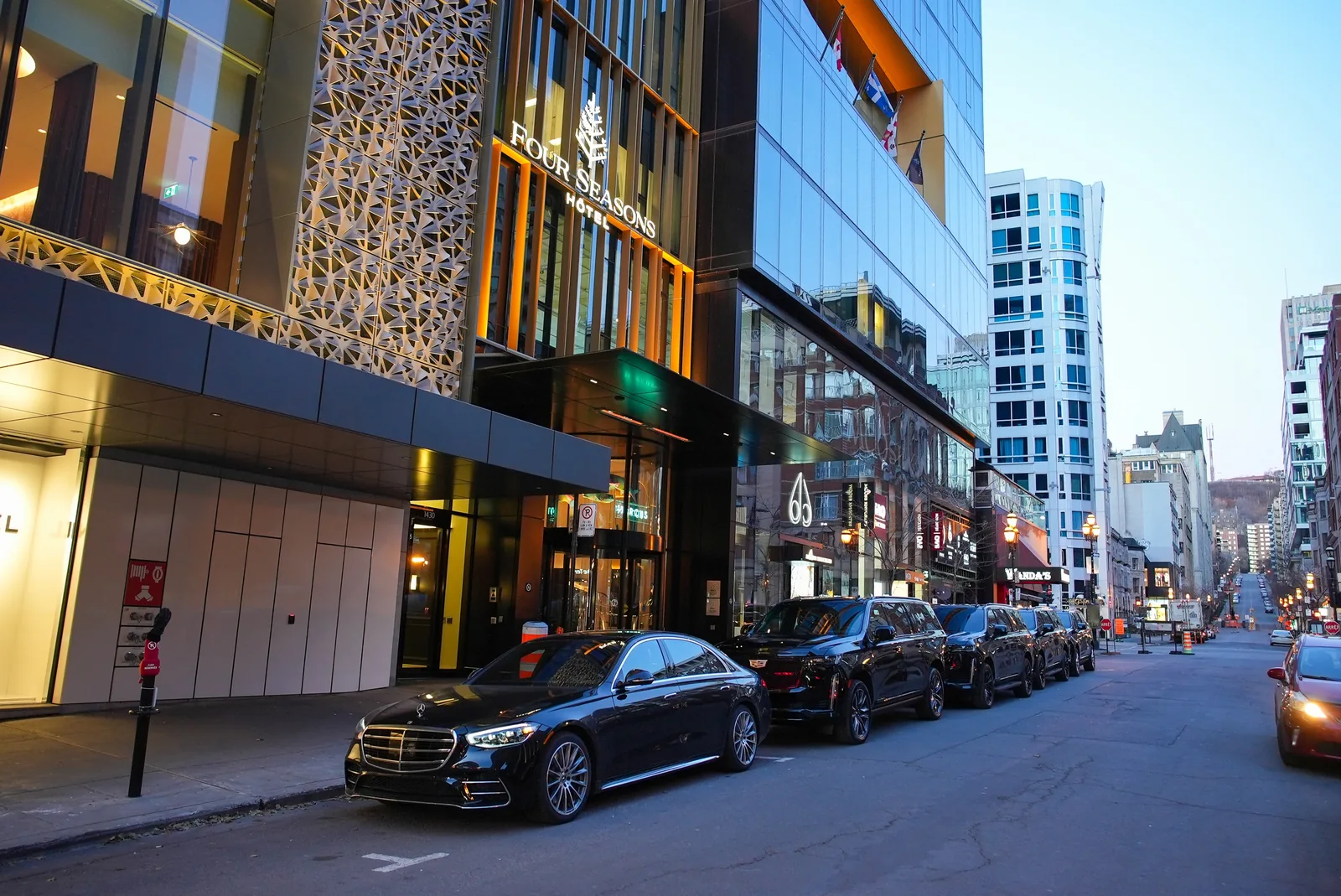Sedán Mercedes y SUV Cadillac frente al Four Seasons Hotel Montréal.