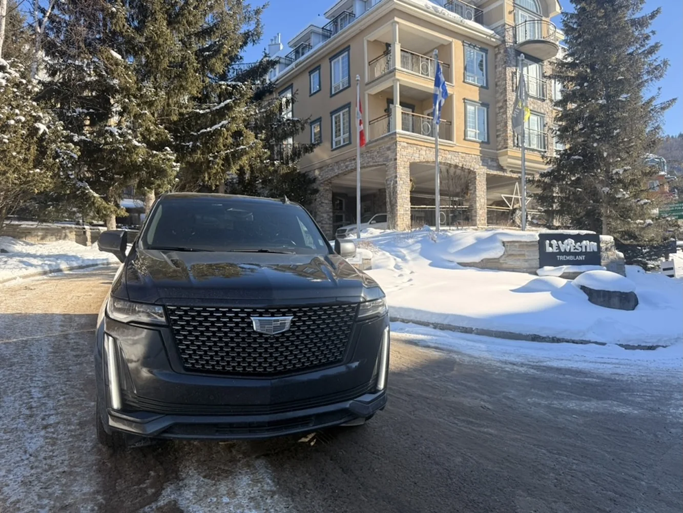 Cadillac Escalade en Le Westin Tremblant junto al letrero del hotel y la nieve.